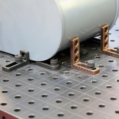 Workpiece mounted with clamps on metal welding table. Image Credit: Shutterstock.com/genkur