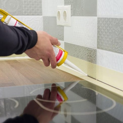 Applying silicone sealant with construction syringe. Image Credit: Shutterstock.com/VH-studio